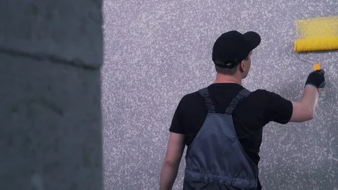 Worker paints a wall with a roller Stock Footage 121189095