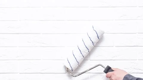 Worker paints the white wall white cushion Stock Footage 194116387
