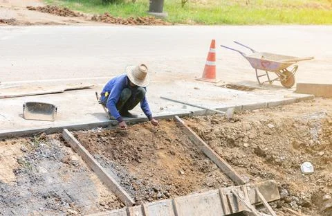 Worker paste wire mesh for pour concrete on side road. Stock Photos