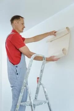 Worker pasting wallpapers. Stock Photos
