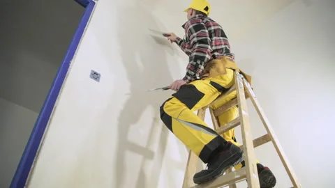 Worker Patching Drywall by Caucasian Worker Vídeos de archivo 154774475