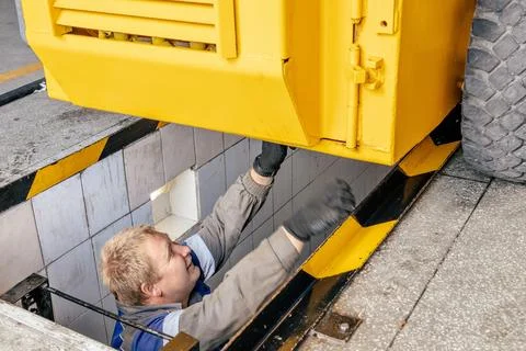 Worker Performing Maintenance on Heavy Machinery Equipment Stock Photos