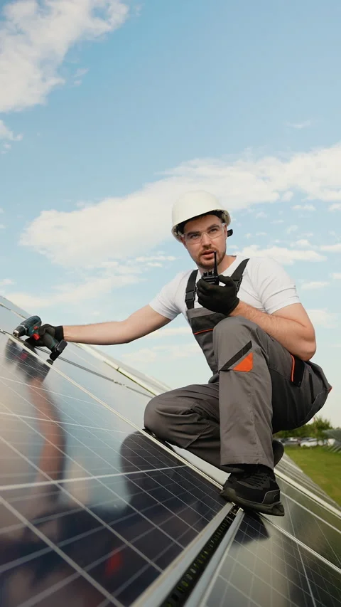 Worker performing solar panel maintenance and communication via a radio Stock Footage 287589145