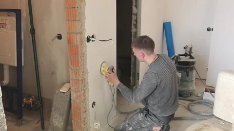 Worker performs drywall installation in a residential area in the afternoon Stock Footage 329706528