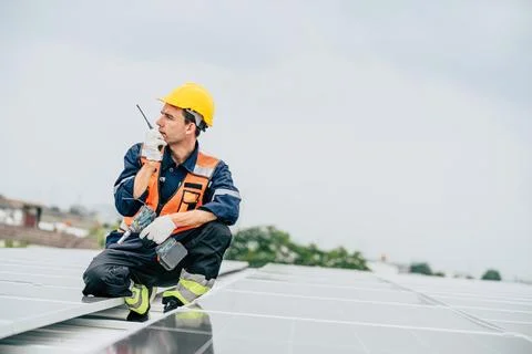 Worker performs maintenance on solar panels while assessing the system at a.. Foto stock