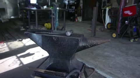 Worker Picking up Hammer from Anvil (wide) Stock Footage 12660163