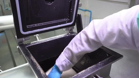 A worker picks up hot cheese from the machine Stock Footage 129928190