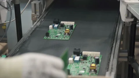 Worker picks up printed circuit boards from the assembly line. PCB on conveyor Stock Footage 144343957