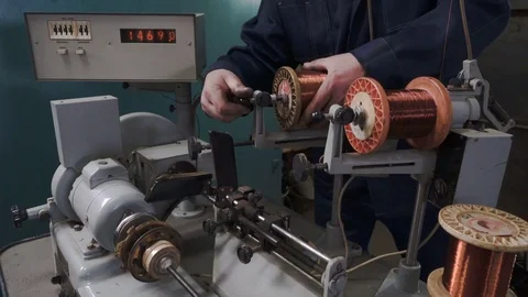 The worker places the coil with copper wire in the winding machine. Electric Video stock 75152176