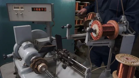 The worker places the coil with copper wire in the winding machine. Electric Video stock 75152245