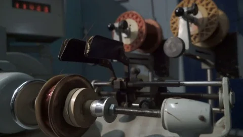 The worker places the coil with copper wire in the winding machine. Electric Video stock 75340422