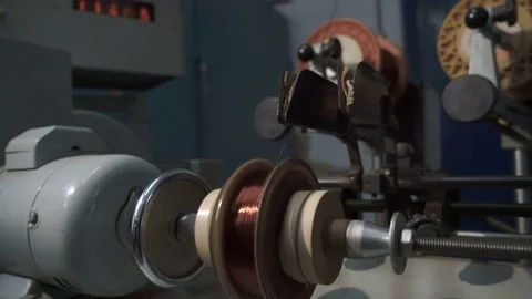 The worker places the coil with copper wire in the winding machine. Electric Stock Footage 75340687