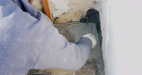 Worker places a PVC sleeve with quick-setting mortar for draining rainwater f Stock-Footage 168349116