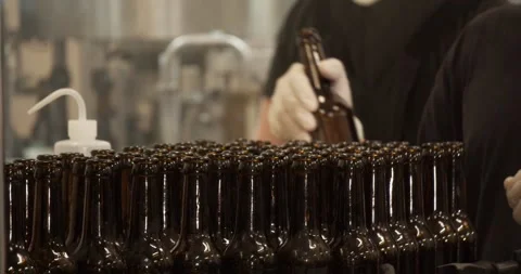 Worker placing beer bottles on conveyor belt in Berlin brewery factory Stock Footage 335143412