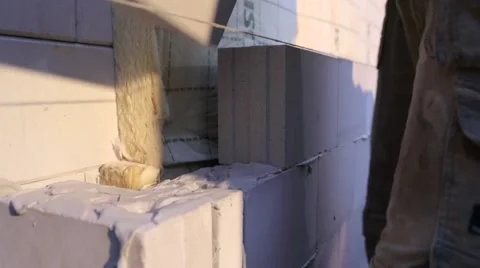 Worker placing a cement block on a wall Stock Footage 60442473