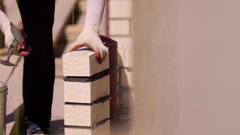 Worker placing ceramic brick on fresh mortar during wall construction close up Stock Footage 341987213