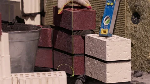 Worker placing ceramic brick on mortar beside spirit level close up Stock-Footage 341987106