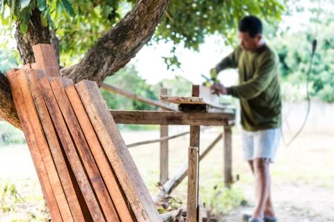 Worker planing a plank of wood with a electric plane Stock Photos