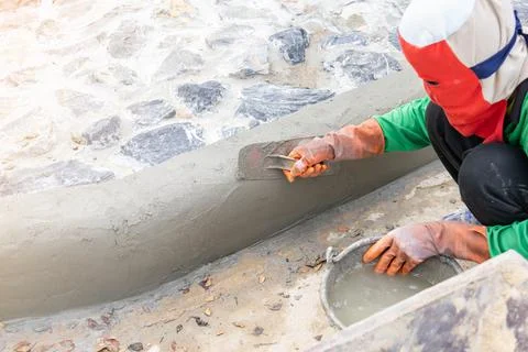 Worker plasterer mortar edge of sidewalk. Stock Photos