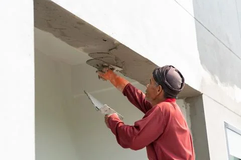 Worker plastering cement. Stock Photos