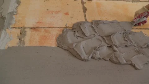 Worker plastering concrete block wall with cement mortar using trowel Stock Footage 335516446