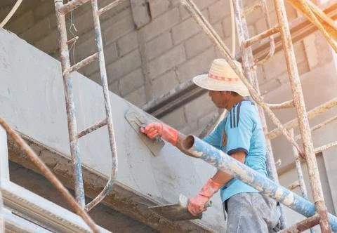 Worker plastering tool plaster cement on interior plaster. Stock Photos
