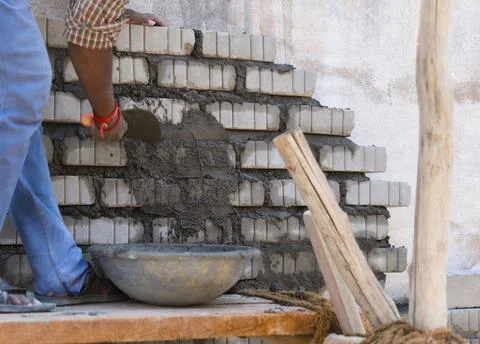 Worker plastering a wall with cement mortar and trowel Stock Photos