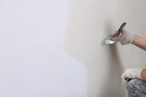 Worker plastering wall with putty knife indoors, closeup. Space for text Fotos de archivo
