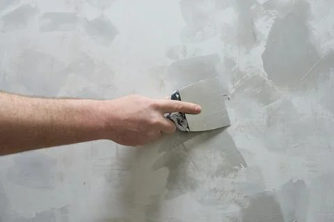 A worker is plastering a wall with a trowel. Stock Photos