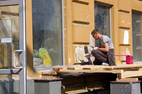 A worker plasters the outer wall Stock Photos