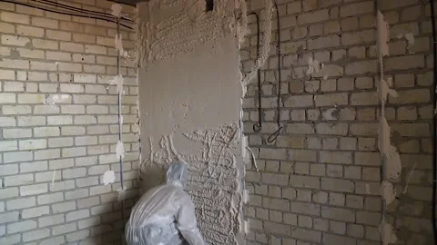 Worker plasters a wall at a construction site. overall plan Vídeos de archivo 146531530