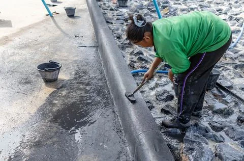 Worker polish surface exposed aggregate finish. Stock Photos