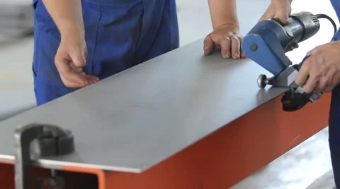 A worker polishes the edge of the metal sheet Vidéo 62812334