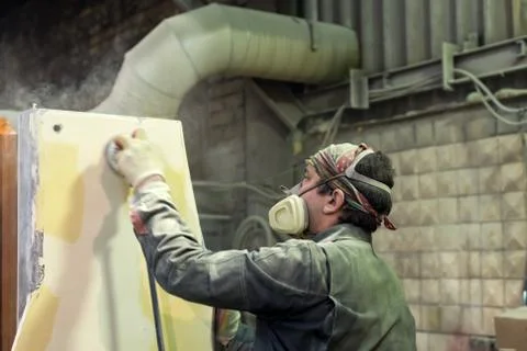 The worker polishes the primer layer. Work on the preparation of the machine bed Stock Photos