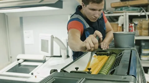 Worker at Polygraphy printing industry use Yellow paint on ink roller Stock Footage 68385412