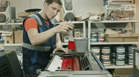 Worker at Polygraphy printing industry use Red paint on ink roller Stock Footage 68385456