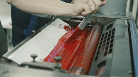 Worker at Polygraphy printing industry use Red paint on ink roller, close up Stock Footage 68385497