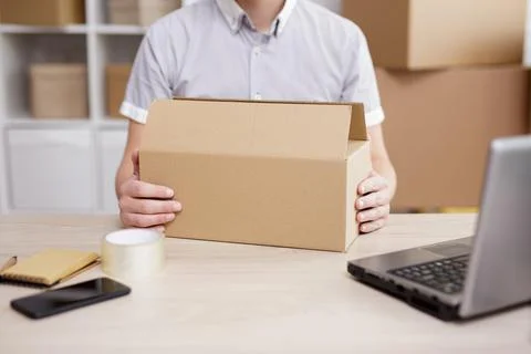 Worker in post office preparing parcels for shipment to client. Stock Photos