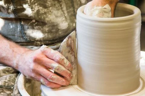 Worker potter in the workshop sculpting ceramic vase. Stock Photos
