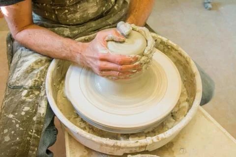 Worker potter in the workshop sculpting ceramic vase. Stock Photos