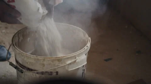 Worker pounces dry mixture into the container for mixing with water Stock Footage 90848167