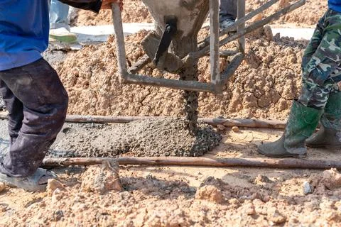 Worker pour lean concrete on formwork before steel rebar foundation Stock Photos