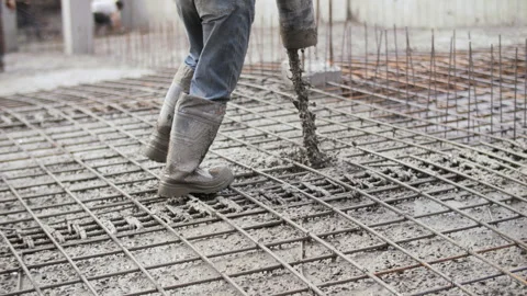 Worker pouring and vibrating concrete on reinforcement at construction site Stock Footage 315562500