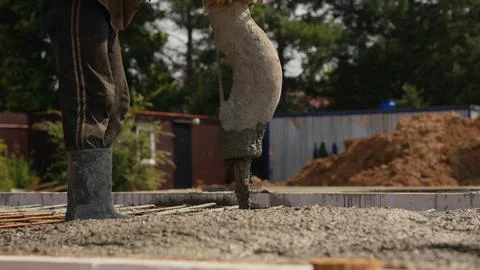 Worker pouring concrete foundation using pump at construction site Stock Photos