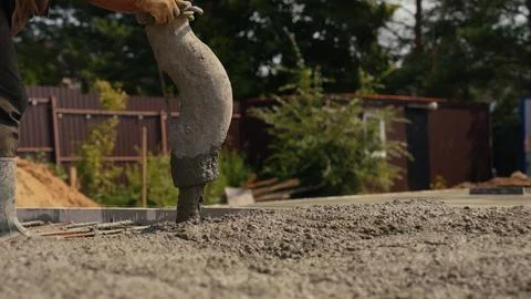 Worker pouring concrete mix creating new foundation Stock Photos