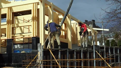 A worker pouring concrete mix formwork on a concrete retaining wall. Stock Footage 234786126