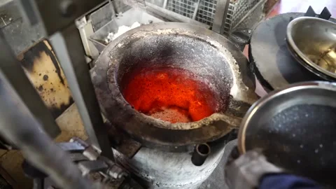 Worker pouring glowing molten metal into crucible pot in cast iron foundry 스톡 동영상 345015980