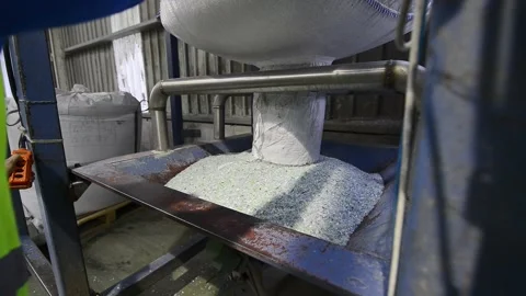 Worker pouring plastic pellets from a bag into an industrial machine Stock Footage 332650188