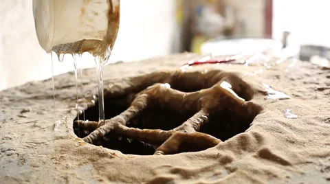 Worker pouring a viscous liquid into a mixer of sand Stock Footage 58638917