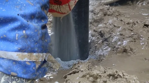 Worker pours cement down side of well pipe Stock Footage 77278411